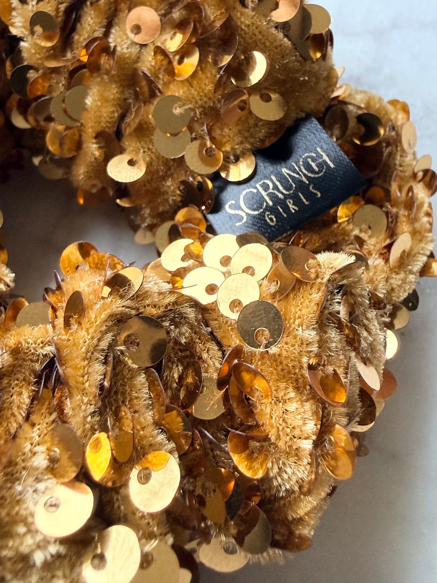 Jenaye. | A gold sequin Scrunchie.