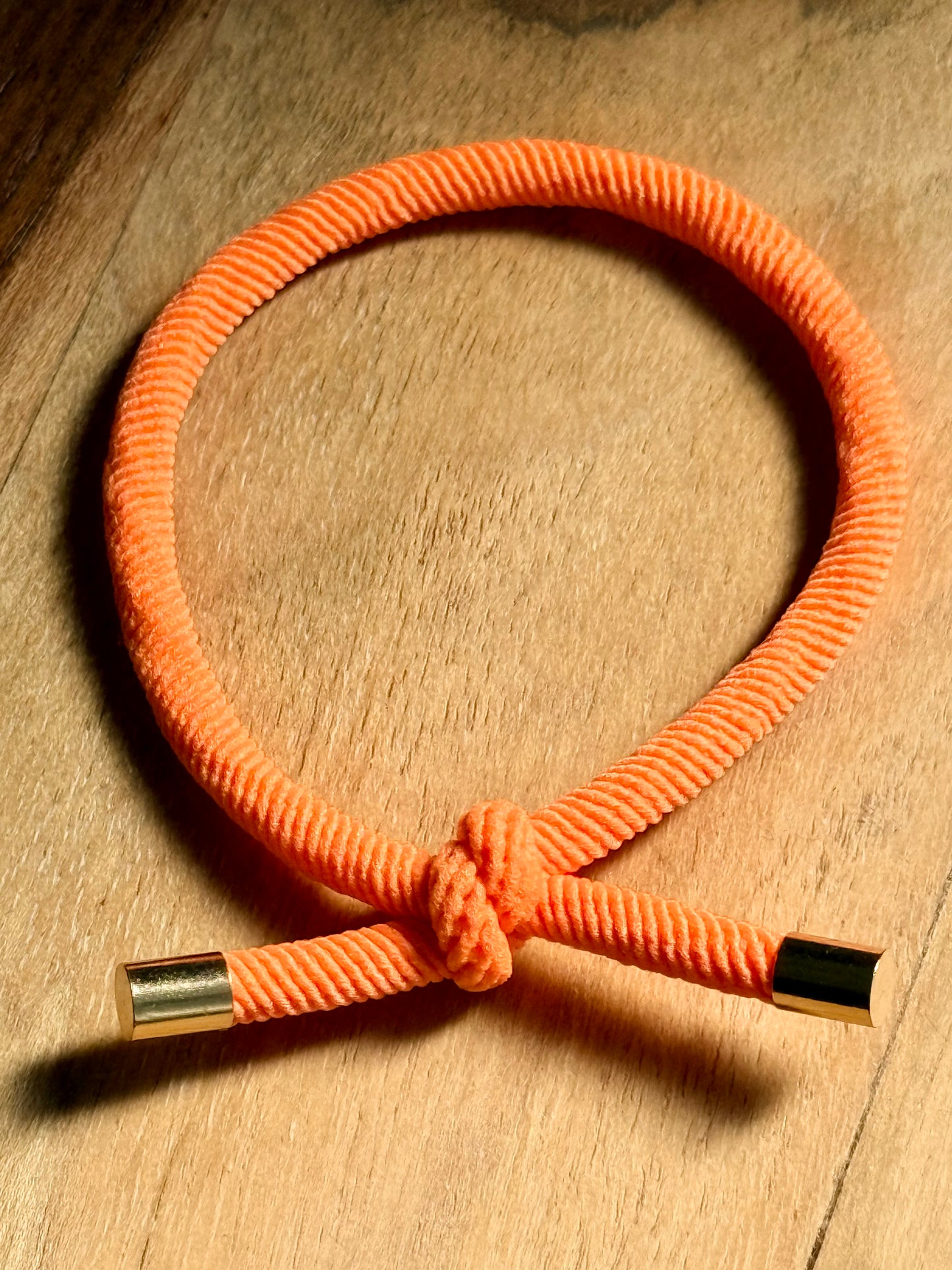 Orange cord with metal ends on a wooden surface