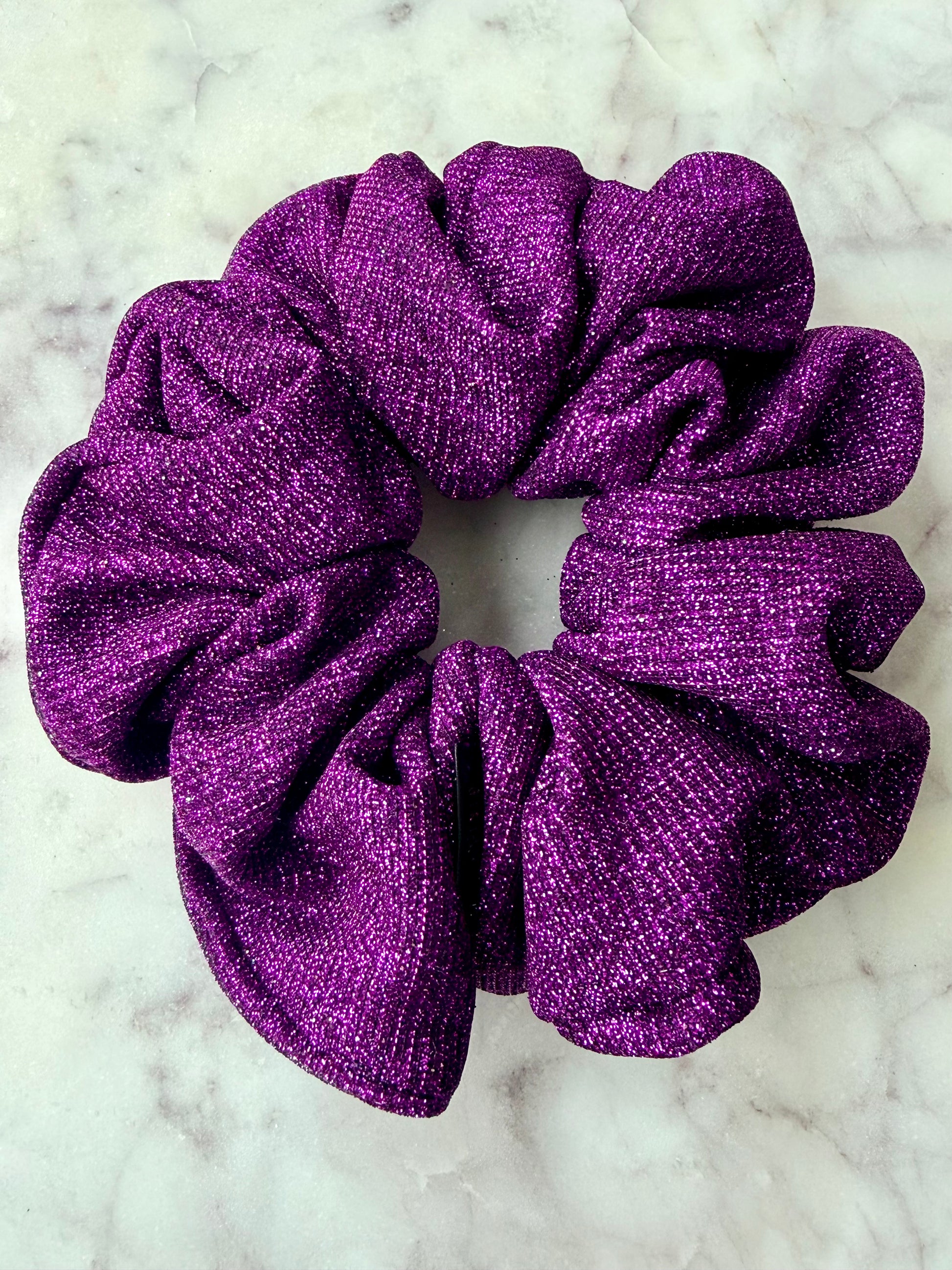 Purple glittery scrunchie on a marble surface